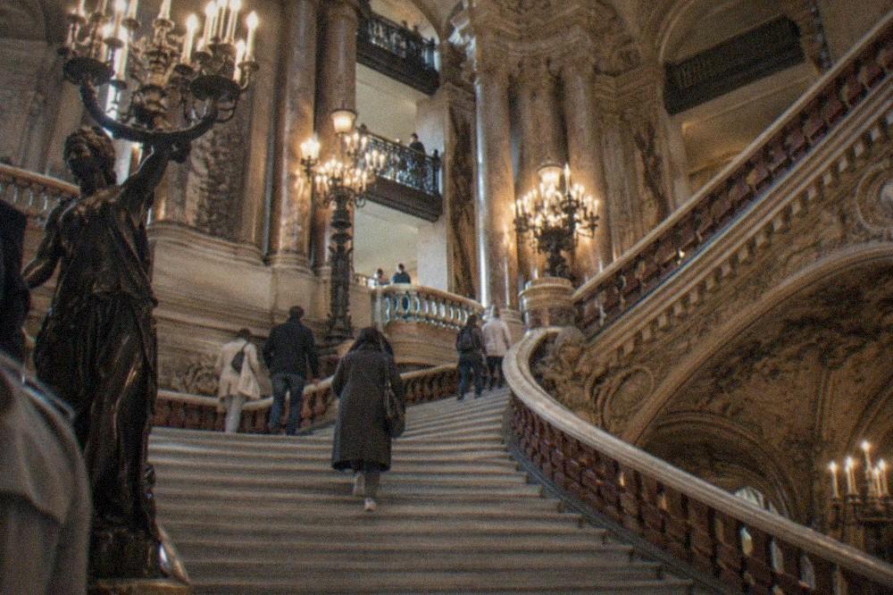 The grand marble staircase of the Palais Garnier with its gilded balustrades