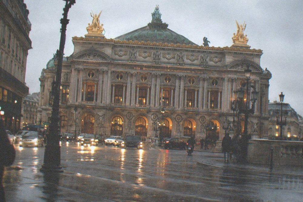 The Palais Garnier facade lit at dusk above the Place de l'Opéra