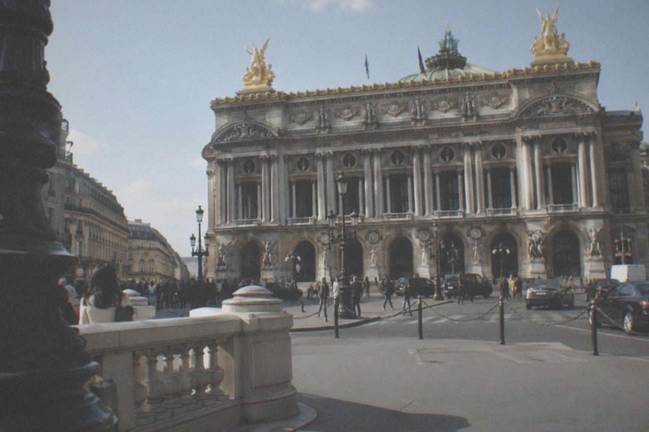 The ornate facade of the Palais Garnier opera house seen from the Place de l'Opéra