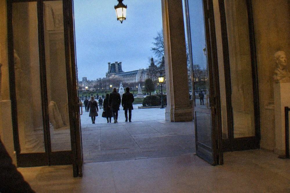 Museum ticket hall entrance with glass doors opening onto a stone terrace in the Tuileries garden