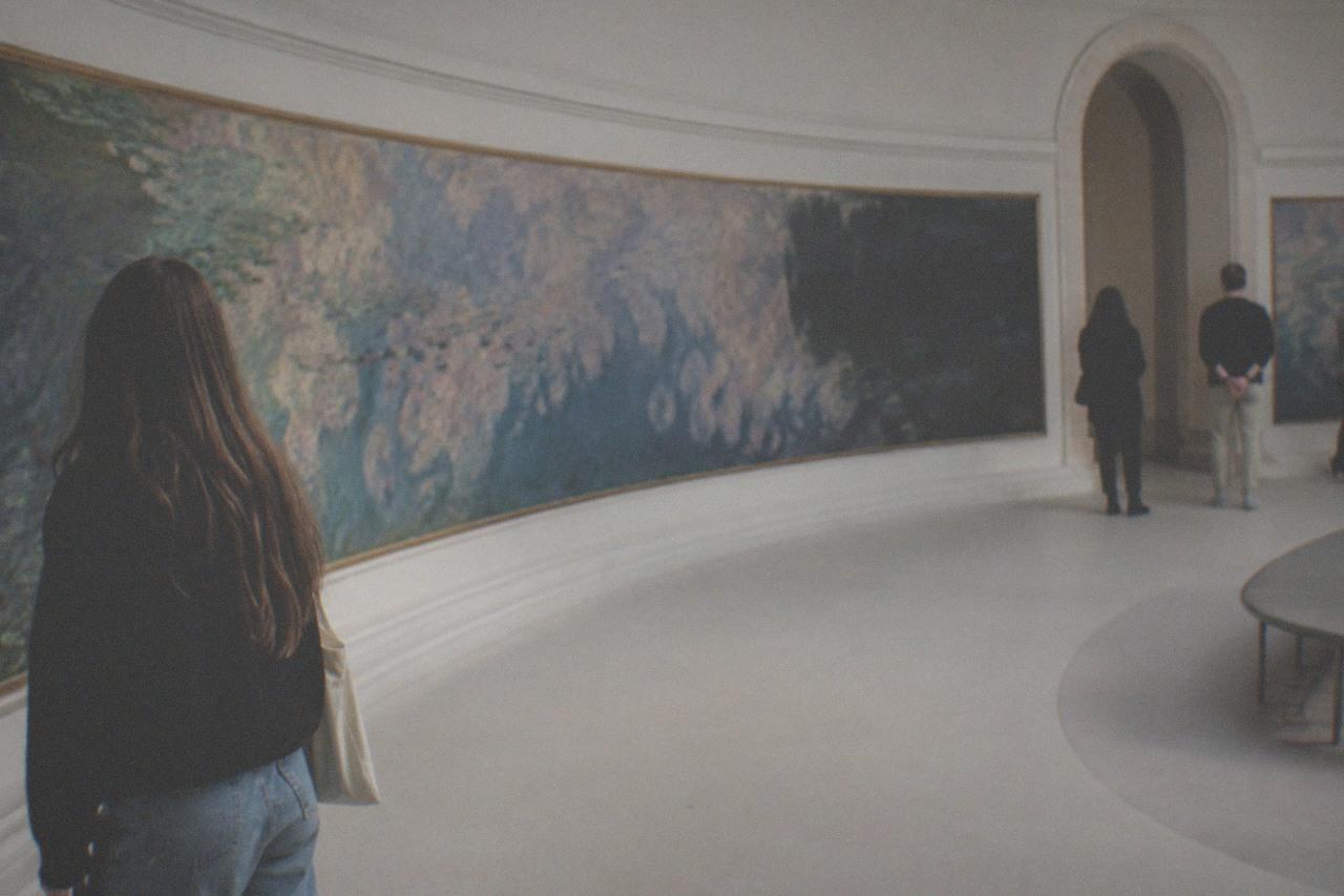 Oval gallery with Monet water lily murals curved along the walls under soft diffused light
