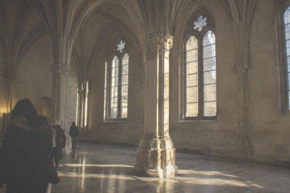 Medieval stone hall with ribbed vaulted ceiling and arched windows