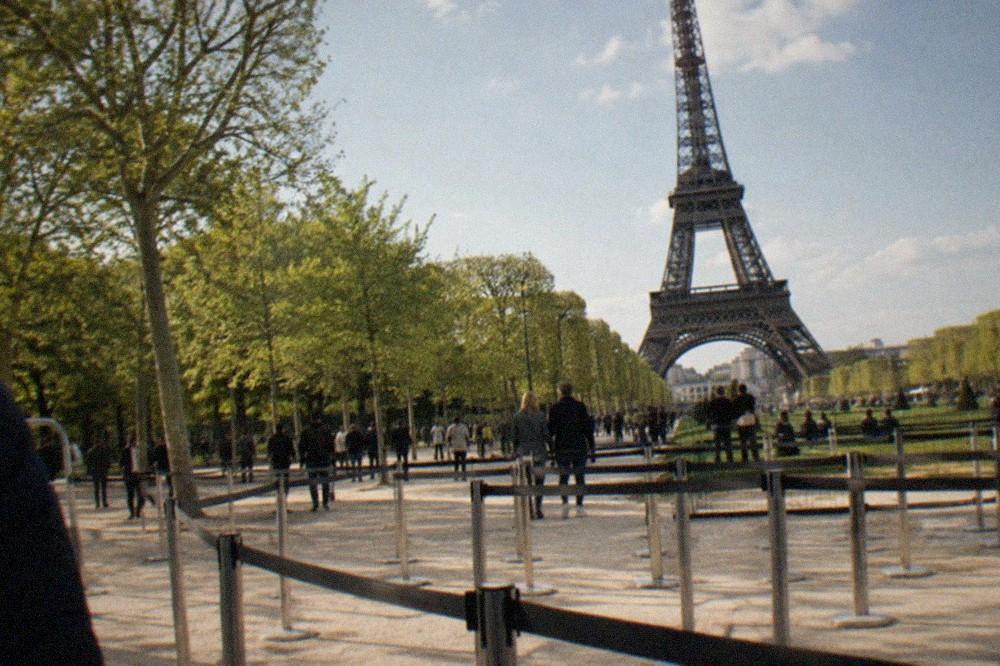 The Eiffel Tower seen from the Champ de Mars with the ticket queue barriers in the foreground