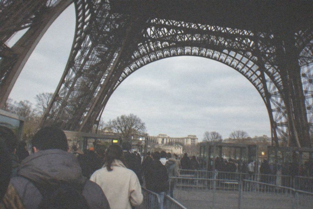 Visitors waiting at the security barriers beneath the Eiffel Tower before the lifts
