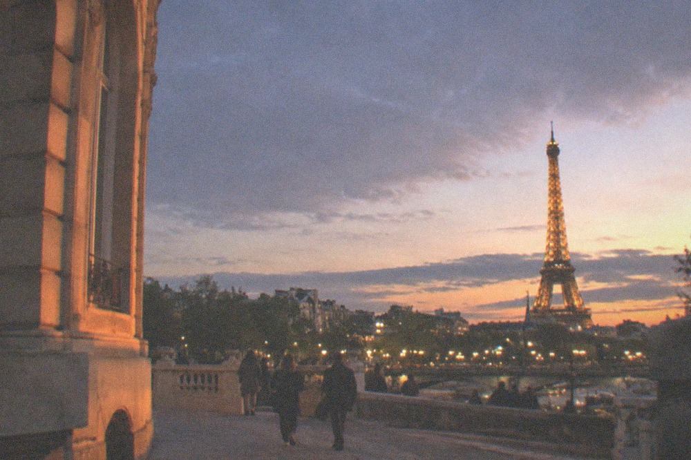 The Eiffel Tower illuminated against a darkening sky over Paris