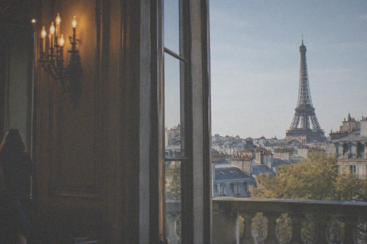 The Eiffel Tower rising above rooftops on a clear afternoon in Paris