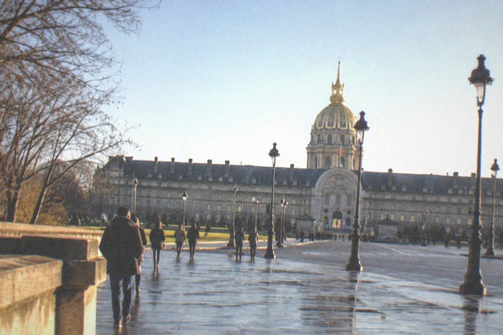 The wide stone esplanade in front of Les Invalides with the golden dome rising against a clear sky