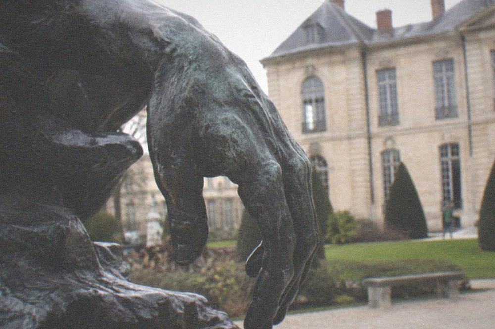 A close view of a weathered bronze hand sculpture in the Rodin collection