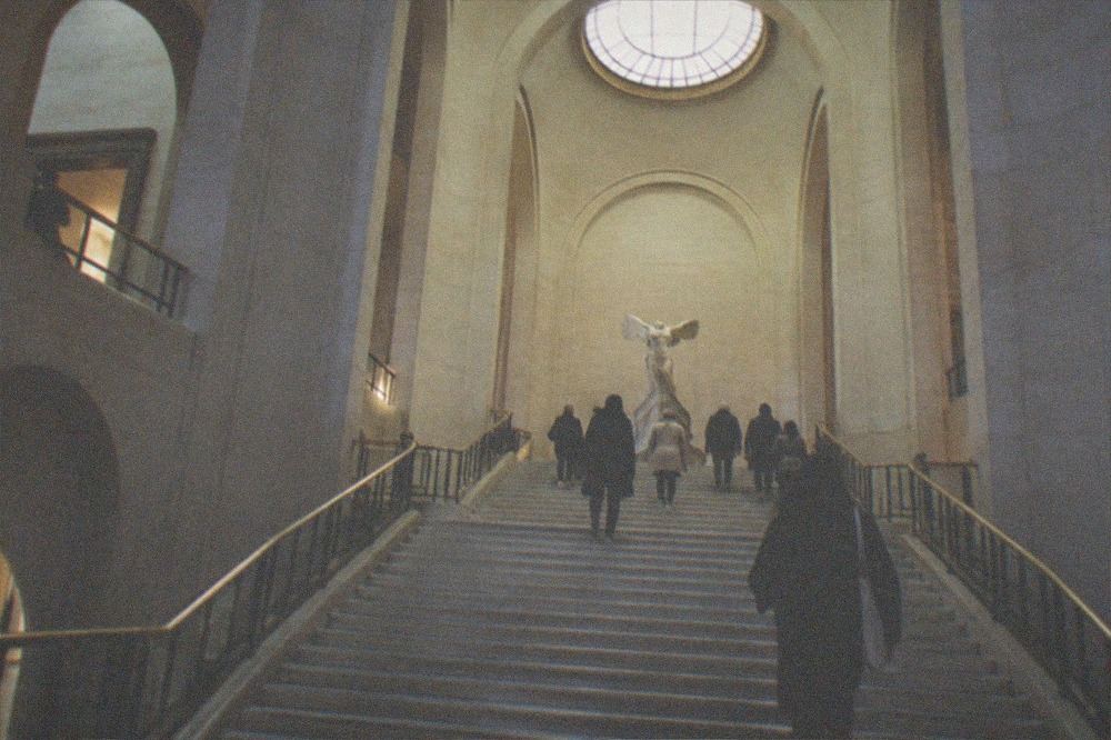 The Daru staircase rising toward a sculpture landing lit by a skylight