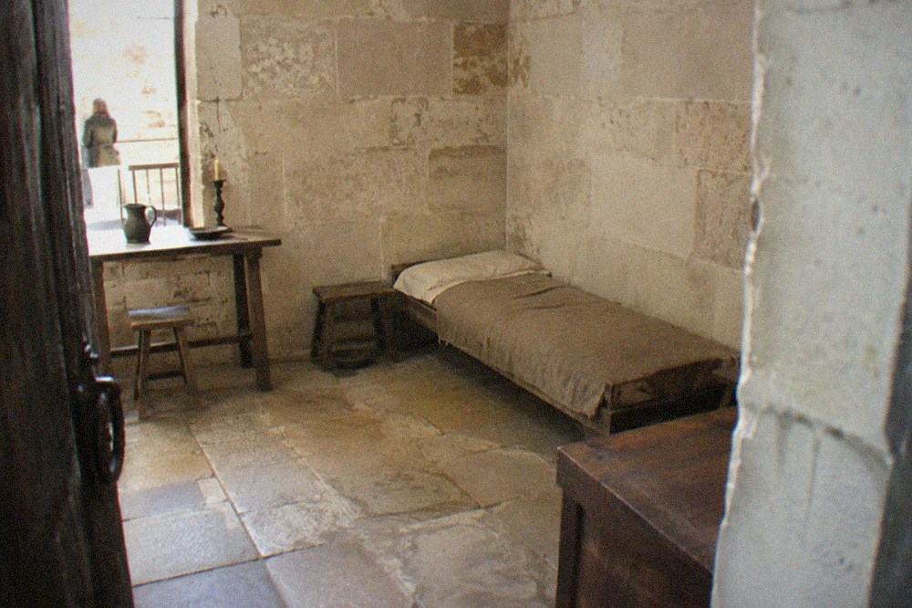 Reconstructed prison cell with a low bed and period furniture inside the Conciergerie