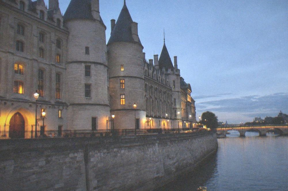 Outer wall of the Conciergerie beside the Seine with turrets and medieval towers along the river