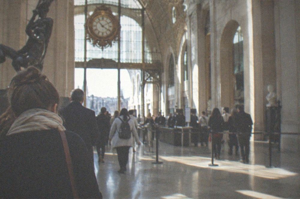 A ticket entrance area of the Musee d Orsay with sunlight falling across the stone floor