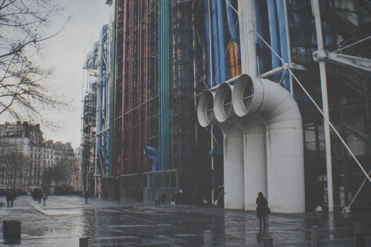 The coloured exterior pipes of the Centre Pompidou building seen from the plaza below