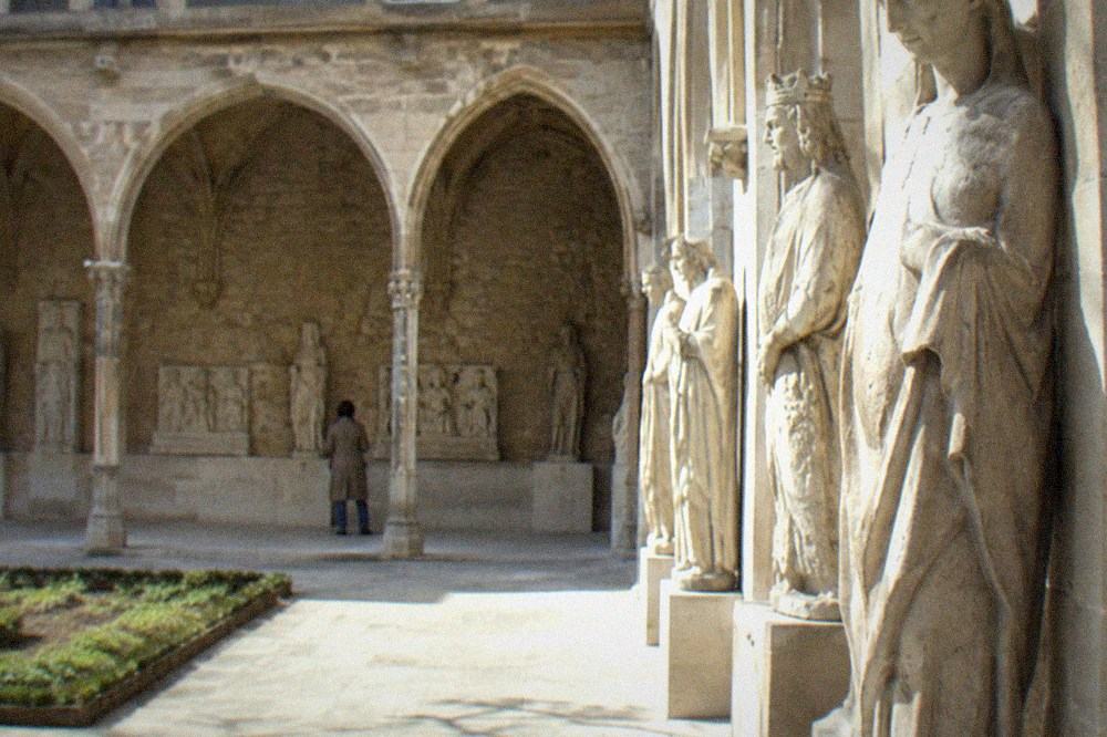 Medieval carved stone sculptures displayed in a stone gallery of the Musee de Cluny