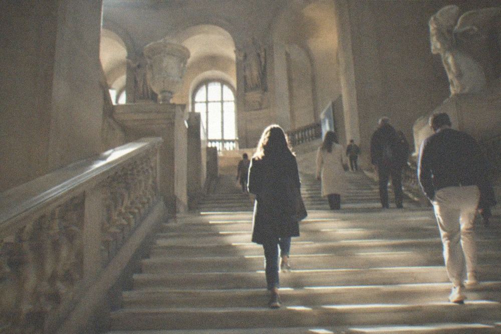 Sunlight falling on a wide stone staircase inside a grand museum atrium
