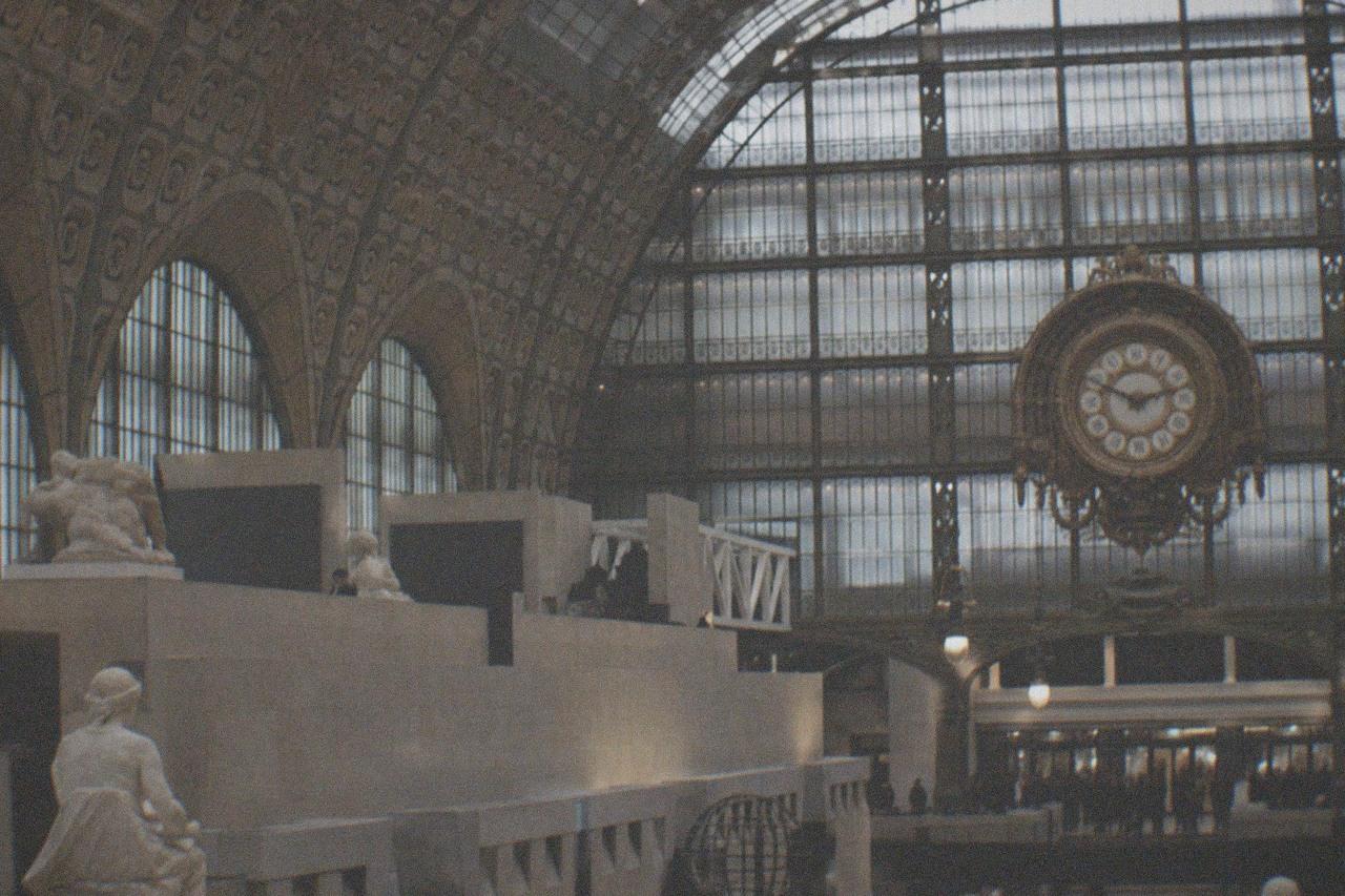 Grand clock faces inside the main hall of a converted Paris railway station