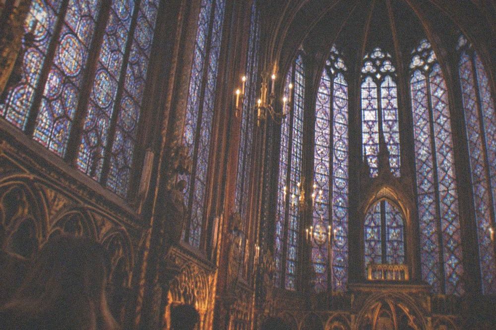 The upper chapel of Sainte-Chapelle with tall stained glass windows filling the walls with colour