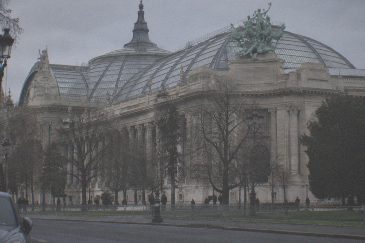 The glass roof and stone facade of the Grand Palais seen from the Avenue Winston Churchill in Paris