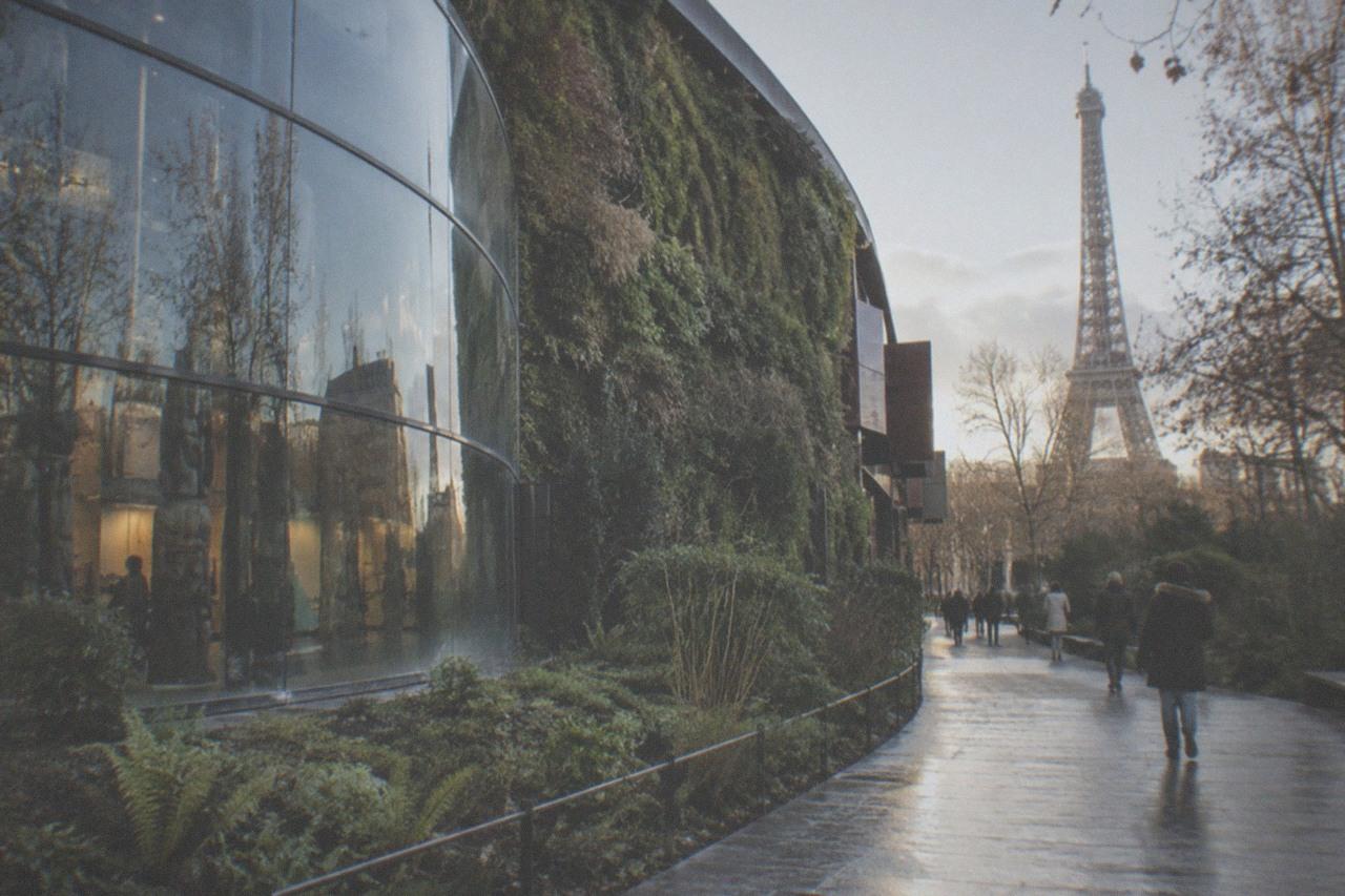 The curved glass and planted green wall of the Musee du quai Branly museum beside the Seine in Paris