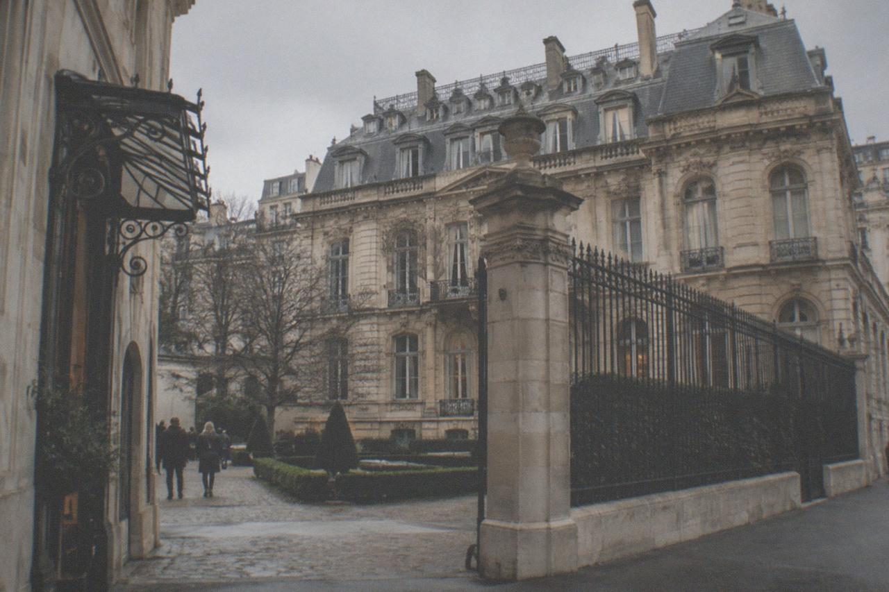 The stone facade and walled courtyard of a grand 19th-century Paris mansion museum on boulevard Haussmann