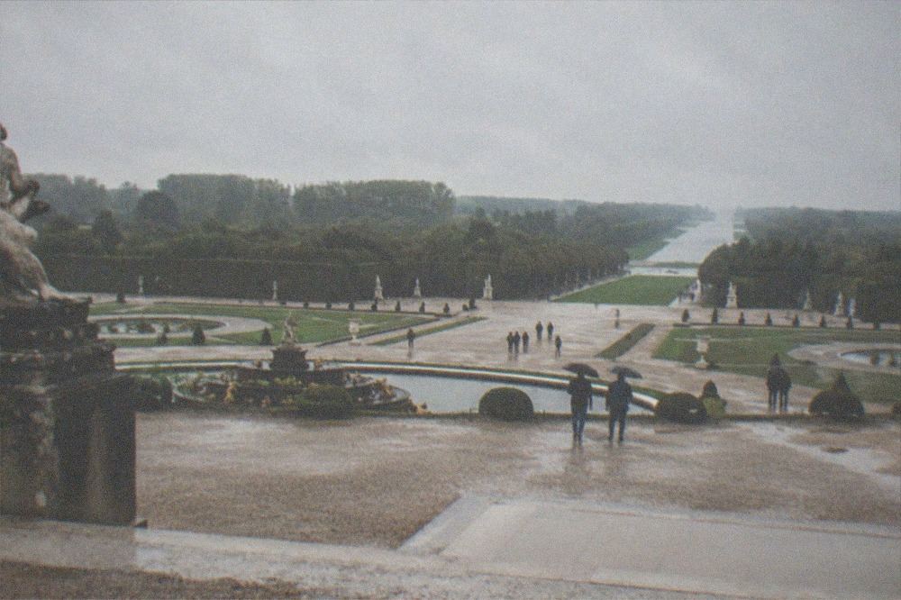 A vast formal French garden with long gravel avenues, basins and clipped trees stretching to the horizon