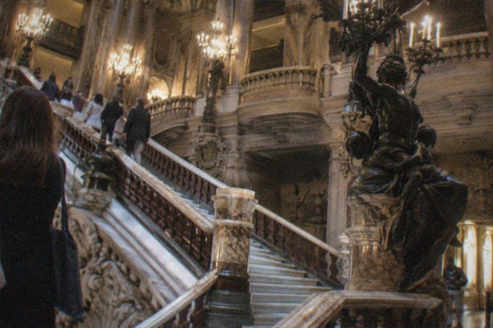 Ornate gilded opera house foyer with a grand marble staircase