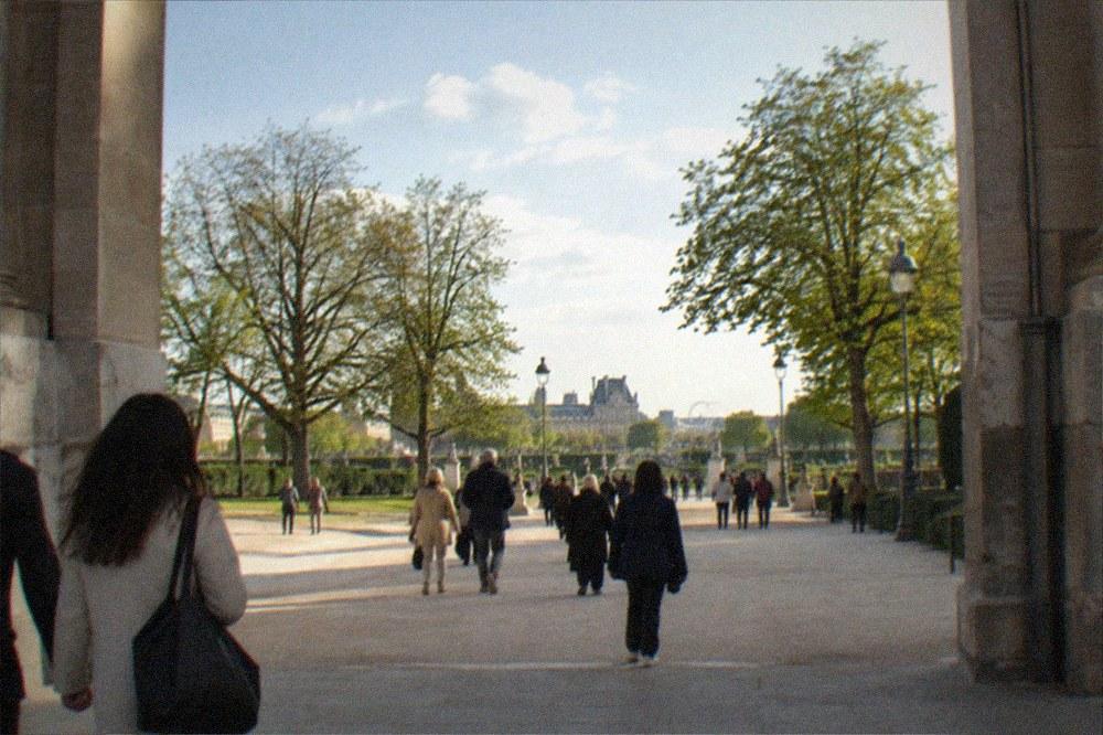 Wide Paris avenue seen from a grand arch toward gardens