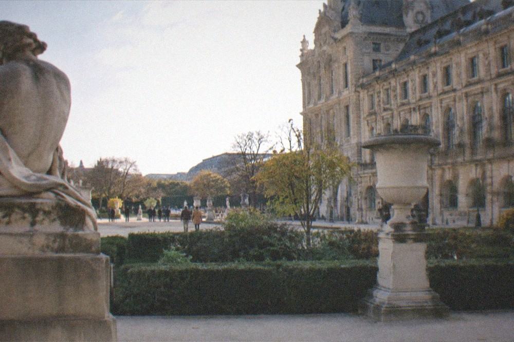 Sunlit sculpture garden beside a classical Paris museum building