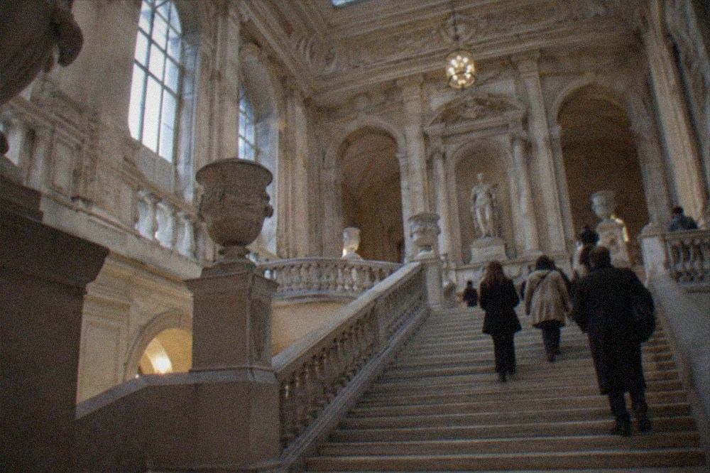 Grand museum staircase lit by an evening skylight in Paris