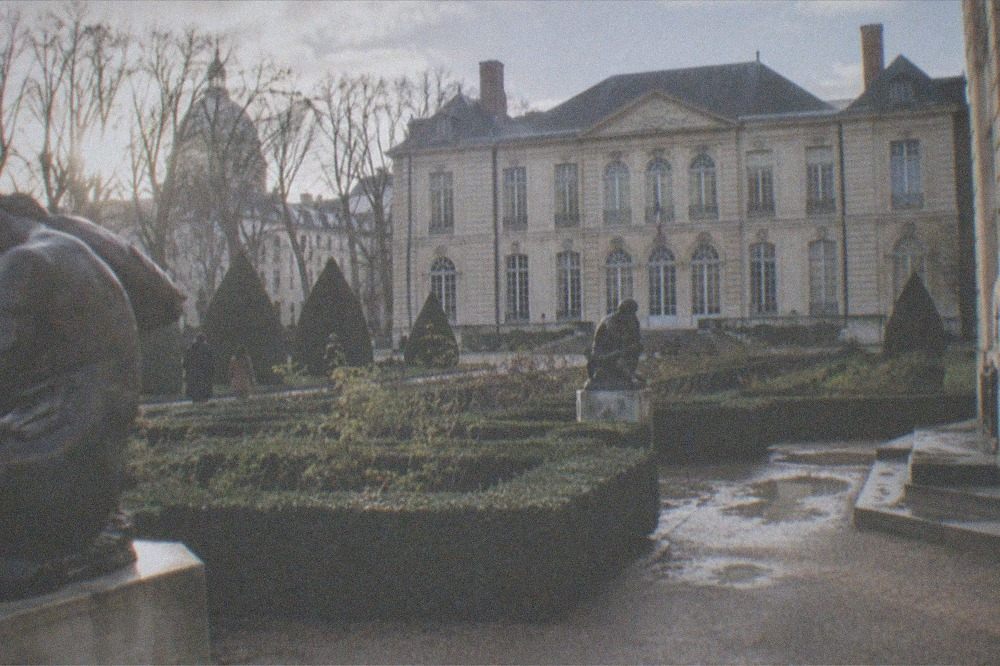 The sculpture garden of the Musée Rodin with hedges and the mansion behind them on a quiet morning