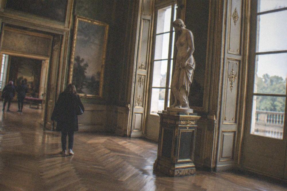 An ornate gallery interior with tall windows and parquet flooring