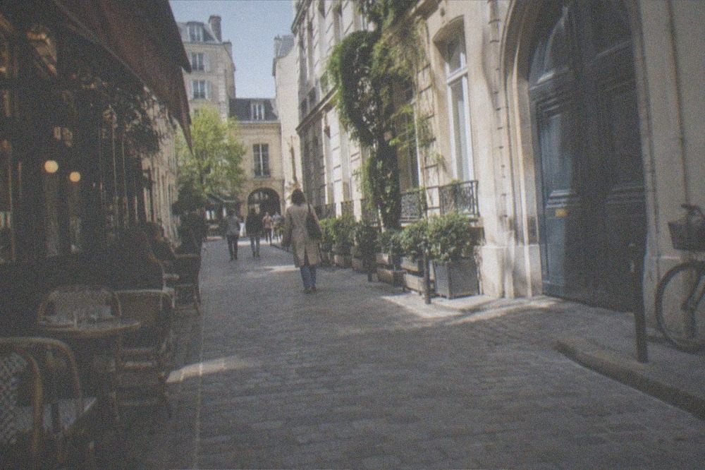A narrow Marais street with old hotel particuliers and café fronts