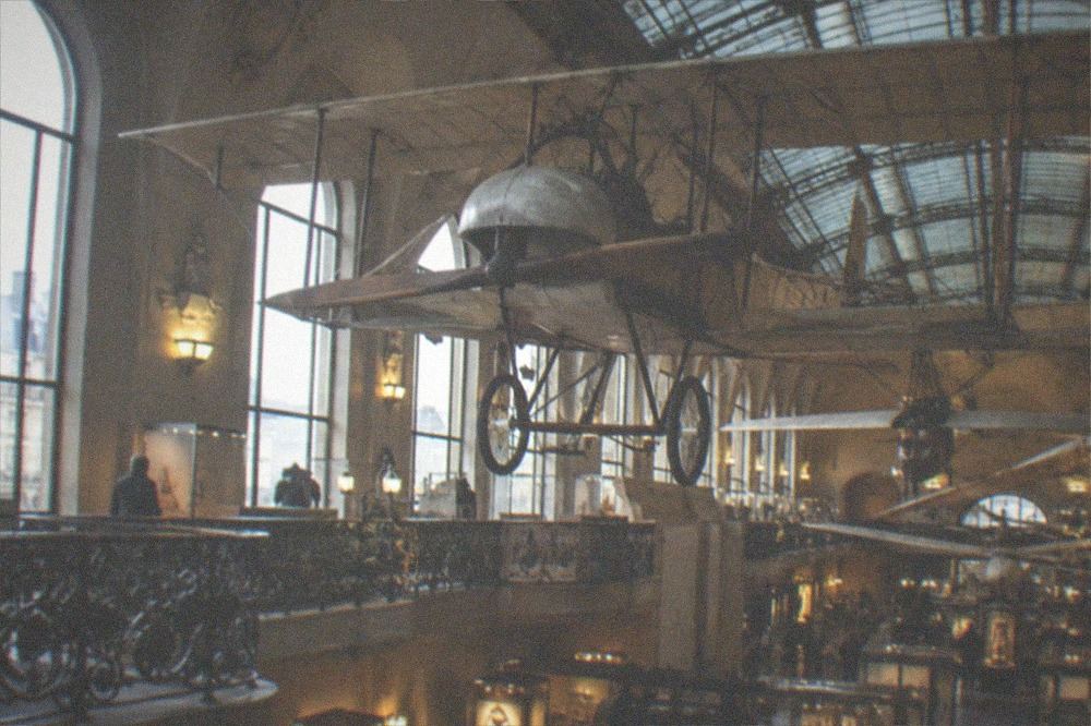 Industrial museum hall with suspended vintage aircraft above the gallery floor