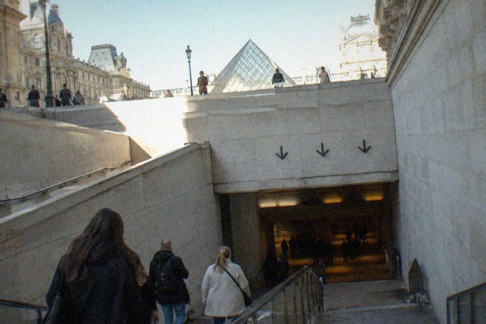 An underground passage leading toward the Carrousel du Louvre entrance with directional signage