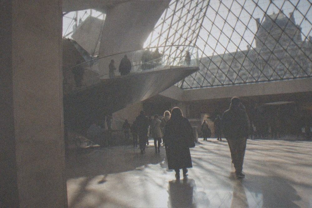 Sunlight falling through the glass roof of a Louvre staircase in the late afternoon