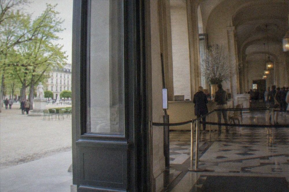 A ticket window and information desk inside a Paris museum entrance hall