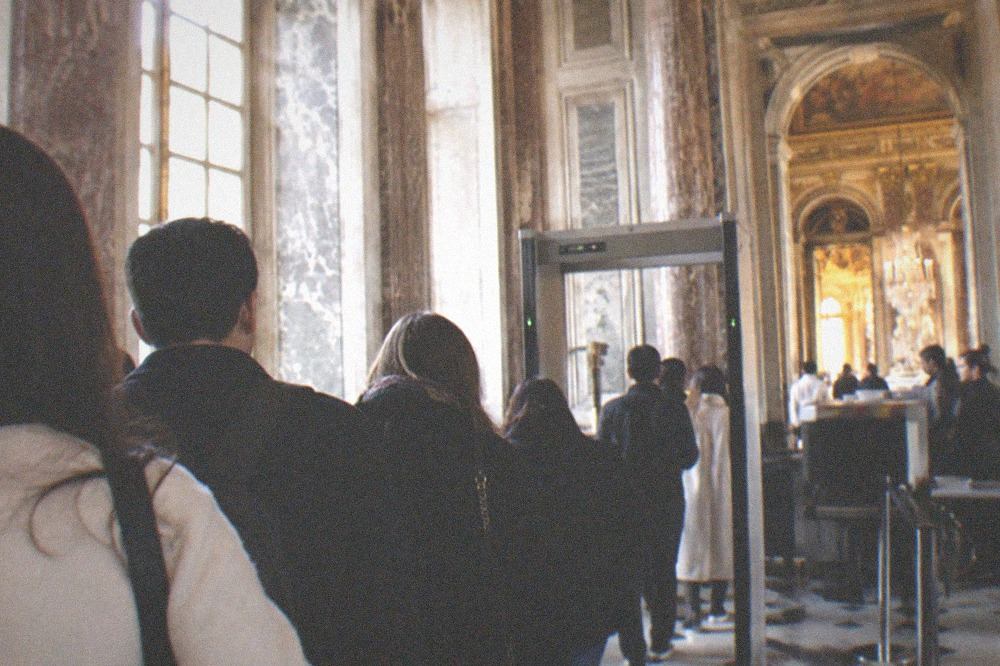 Visitors queueing at a security entrance gate of the Versailles palace
