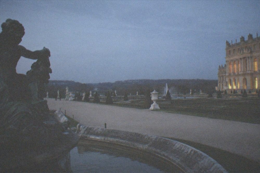 The formal gardens of Versailles with geometric lawns, fountains and clipped hedges stretching to the horizon